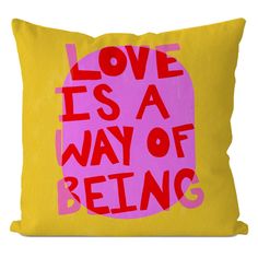 a pink and yellow pillow with the words love is a way of being printed on it