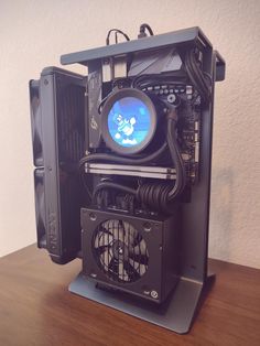 a computer tower sitting on top of a wooden table next to a fan and mouse