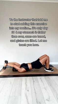 a woman laying on top of a wooden mat in front of a wall with an inspirational quote