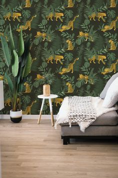 a living room with a couch, plant and wallpaper