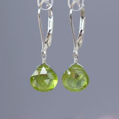 Genuine Peridot Dangle earrings are handcrafted in 14k Gold. MATERIALS: * Solid 14k Gold or 18k Gold * natural peridot * dangling from leverbacks * beautiful branded gift box + card about peridot SIZE: stones: 8x8 mm; earrings: 2.5 cm or 1" MAKE A SET: Matching necklace:  https://etsy.me/2s6lDGN PERIDOT: ∙ August Birthstone ∙ 1st and 16th Wedding Anniversary Gemstone ∙ Talisman for Leo ∙ Heart chakra (Anahata)  Peridot symbolizes inner lightness, safety, and equilibrium. Being a heart chakra sto Green Faceted Round Earrings, Green Round Faceted Earrings, Lime Green Earrings For Gift, Green Briolette Earrings For Wedding, Handmade Peridot Round Earrings, Handmade Round Peridot Earrings, Lime Green Sterling Silver Fine Jewelry, Elegant Lime Green Dangle Earrings, Elegant Lime Green Earrings For Gift