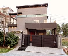 a modern house with an attached gate in the front yard