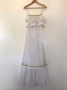 White Cotton Dress | Maxi Summer Dress | Long Prairie Boho Dress | Vintage Dress | Lace Festival Peasant Bohemian | Ruffled Sleeveless Gown | see through dress | white beach dress |  broderie eyelet lace pattern | Tags Description: A brilliant prairie dress from the late 1970s (perhaps early 1980s).  This vintage piece is white and made of cotton.  It is also not see through and has a white inner lining. It features a brilliant broderie eyelet lace pattern throughout and has ruffle detail on the Bohemian Maxi Dress With Ruffled Straps, Bohemian Maxi Dress With Ruffle Hem And Straps, Bohemian Sundress With Ruffled Straps For The Beach, Bohemian Sundress With Ruffle Hem And Straps, Bohemian Sundress With Ruffle Hem And Ruffled Straps, Bohemian Sundress With Ruffled Straps, White Ruffled Maxi Sundress, Bohemian Sleeveless Sundress With Ruffle Hem, Bohemian Sleeveless Dress With Ruffle Hem