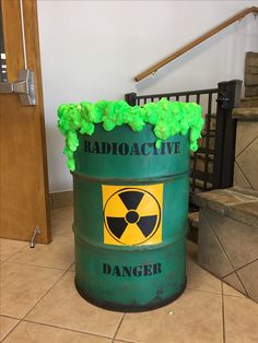 a radioactive waste can sitting on the floor in front of a staircase and stairs with green plants growing out of it