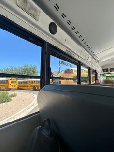 the interior of a school bus with two yellow buses in the background