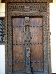 an old wooden door with intricate carvings on the front and side doors are open to let in light