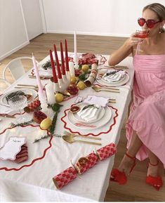 a woman sitting at a table with plates and candles