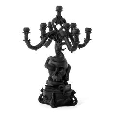 a black and white photo of a candle holder with candles in the shape of a skull