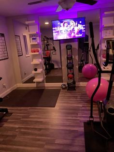 a home gym with exercise equipment and purple lighting