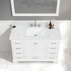 a white bathroom vanity with marble counter top