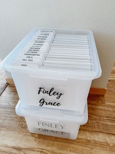 a plastic storage container filled with files on top of a wooden floor