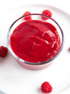 raspberry sauce in a small glass bowl on a white plate