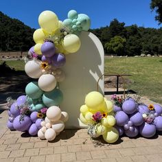 balloons and flowers are arranged in front of a monument