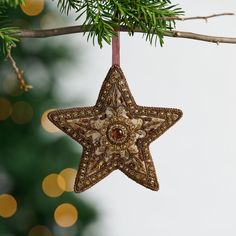 a star ornament hanging from a christmas tree