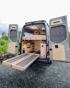 the back end of a van with its doors open and wooden steps up to it