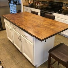 a kitchen island with two stools in front of it