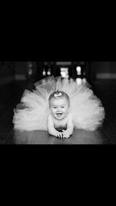 a baby wearing a tutu and smiling for the camera