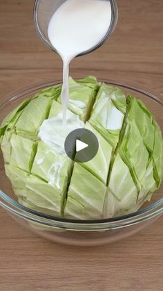 a bowl filled with lettuce and milk being poured into it