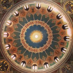 the inside of a dome painted with many different colors and designs on it's ceiling