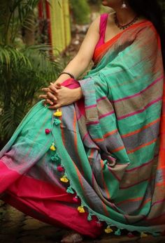 a woman in a colorful sari sitting on the ground