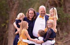 a man in a tuxedo poses with his family