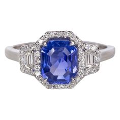 Indulge in the regal allure of this extraordinary ring, featuring a GIA-certified Royal Blue sapphire at its center. Hailing from the illustrious mines of Sri Lanka, this sapphire boasts a rich hue and is exceptionally rare for being non-heated, ensuring its natural and unaltered beauty. The sapphire is cut in an elegant emerald shape, enhancing its allure and sophistication. Flanking the majestic sapphire on either side are two trapezoid-cut diamonds, adding a touch of modernity to the classic Royal Blue Sapphire Ring, Pear Cut Diamond Ring, Sapphire Cocktail Ring, Blue Emerald, Emerald Cut Diamond Ring, Oval Diamond Ring, Emerald Diamond Ring, Cushion Cut Ring, White Diamond Ring