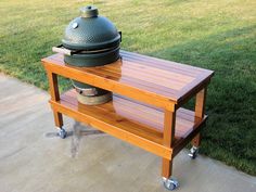 an outdoor table with a large grill on it