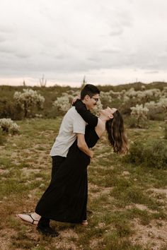 a man and woman kissing in an open field