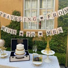 a table topped with a cake covered in white frosting next to a tall building