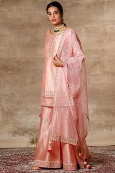 Peach kurta with placement floral embroidery. Comes with sharara pants and dupatta.
Components: 3
Fabric: Chanderi, Organza
Neckline: Round
Sleeve Length: Bracelet
Color: Peach
Embroidered
Kurta with side criss cross tie-up
Sheer panels
Sharara with embroidered hem
Dupatta with tassels
Closure: Kurta: Front loop buttons - Aza Fashions Sharara Pants, Kurta Sharara Set, Kurta Sharara, Peach Shorts, Round Bracelet, White Kurta, Women Kurta, Sharara Set, Ethnic Dress