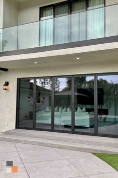 an outside view of a building with glass doors and balconies on the second floor