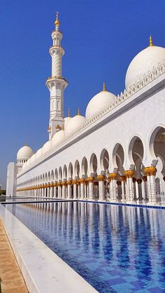 a large white building with a pool in front of it