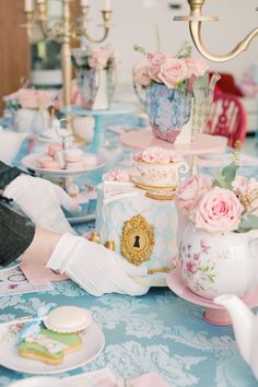 a table topped with plates and cups filled with cake next to a teapot on top of a table