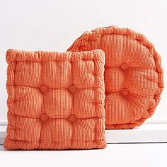 two orange cushions sitting next to each other