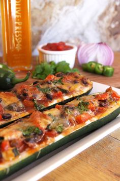 two slices of pizza sitting on top of a white plate next to peppers and onions