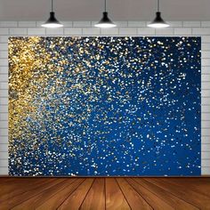 an abstract painting with gold and blue glitters on it in a white brick wall