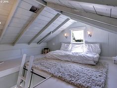 an attic bedroom with white walls and carpet