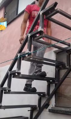 a man standing on top of a metal stair case