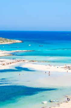 people are on the beach and in the water at this tropical resort, with clear blue waters