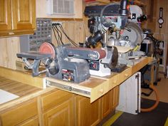 a workbench with some tools on top of it in a room filled with wood cabinets