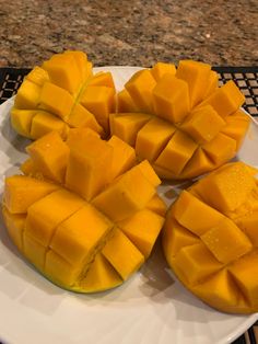 several pieces of mango on a white plate