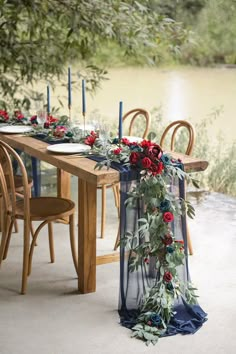 the table is set with candles, flowers and greenery for an outdoor wedding reception