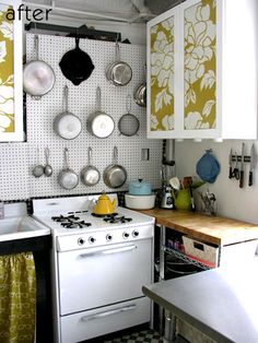 a kitchen with an oven, stove and counter top in the corner next to pots and pans hanging on the wall