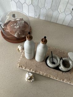 two salt and pepper shakers sitting on top of a counter next to a glass dome