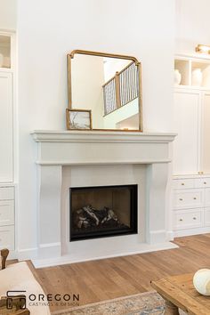 a white fireplace with a mirror above it