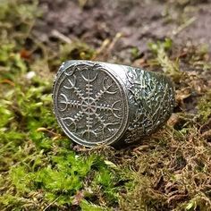 a ring sitting on the ground surrounded by moss