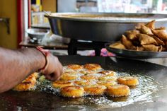 someone is frying some food on a pan in front of other plates and bowls