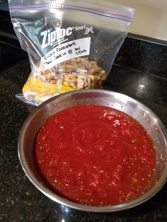 a pan filled with sauce next to a bag of chips on top of a counter