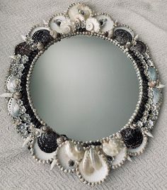 a mirror that has shells and seashells in the frame around it on a bed