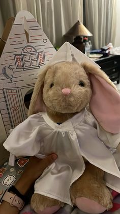 a stuffed rabbit dressed in a white dress